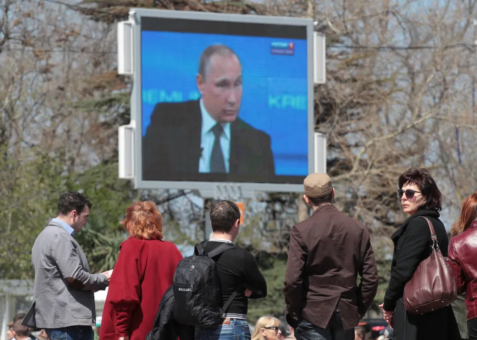Obyvatelé Krymu sledují na obrazovce ruského prezidenta