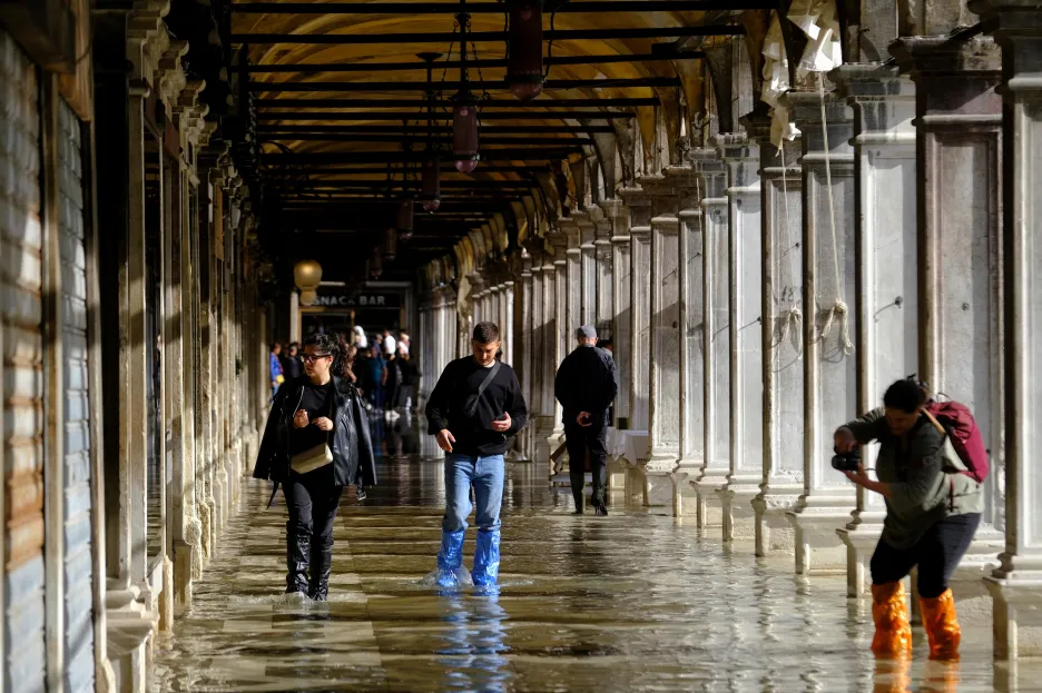 

Sezónní příliv zalil část Benátek. Turisté se brodí naboso nebo s pytli na nohou

