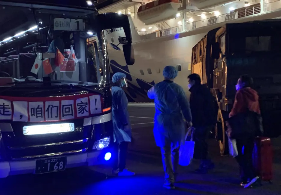 Autobus čekající na cestující, kteří opustili loď Diamond Princess