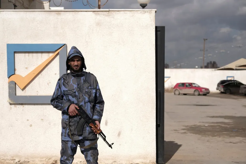 Příslušník bezpečnostních složek před budovou volební komise v Benghází