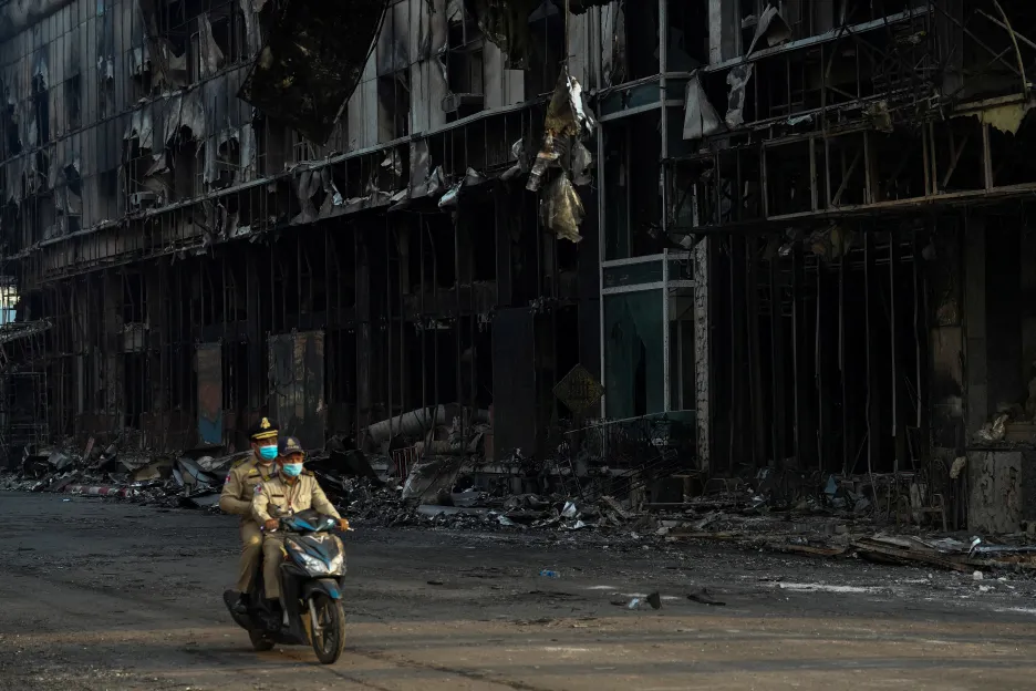 Kambodžští policisté projíždějí kolem vyhořelého hotelu a kasina v Poipetu