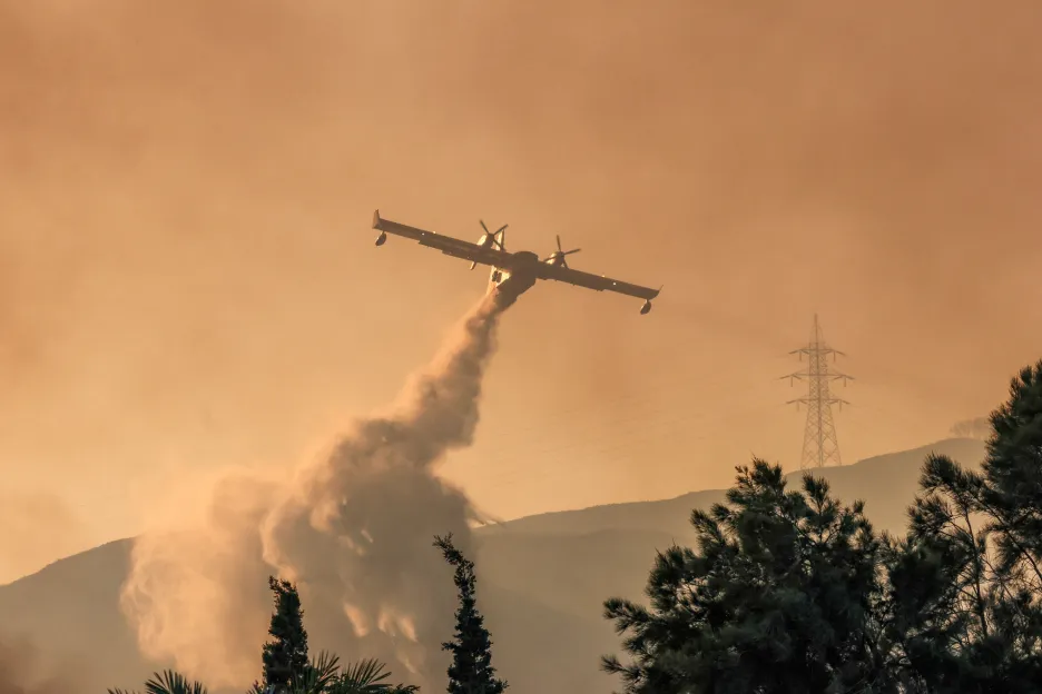 Hasičské letadlo shazuje vodu na požár poblíž vesnice Gennadi