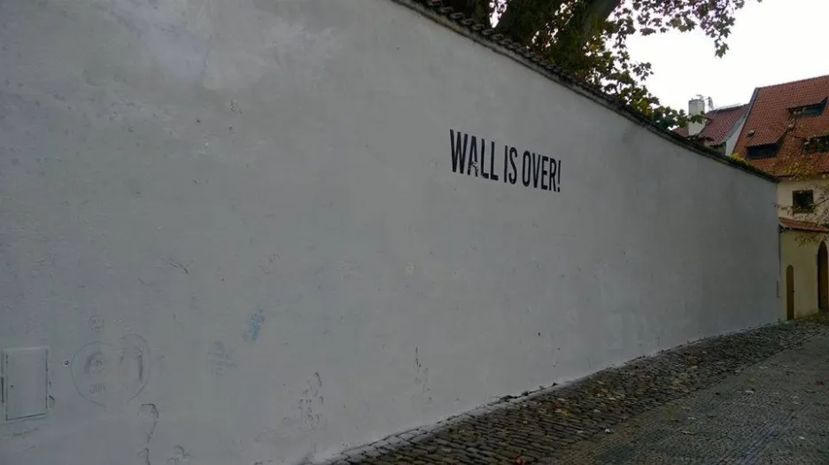 Lennonova zeď přetřená na bílo s nápisem Wall Is Over