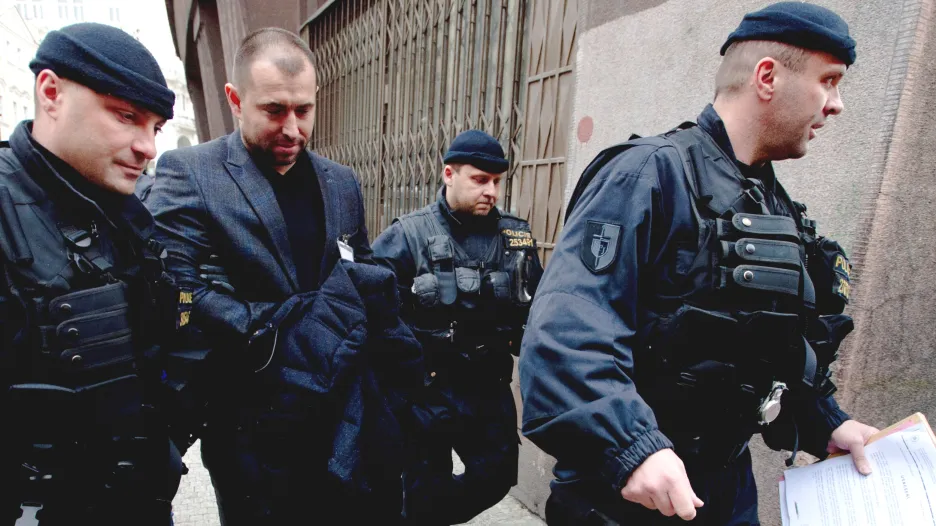 Advokát Ivo Hala v doprovodu policistů