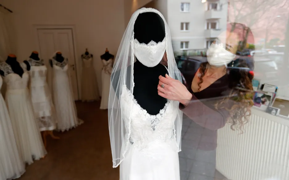 Model svatebních šatů s rouškou v době koronaviru