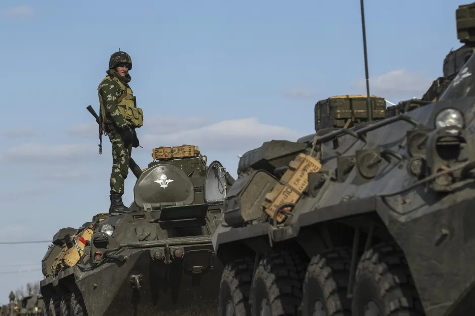 Ukrajinský voják stojící na obrněném transportéru v Chersonské oblasti