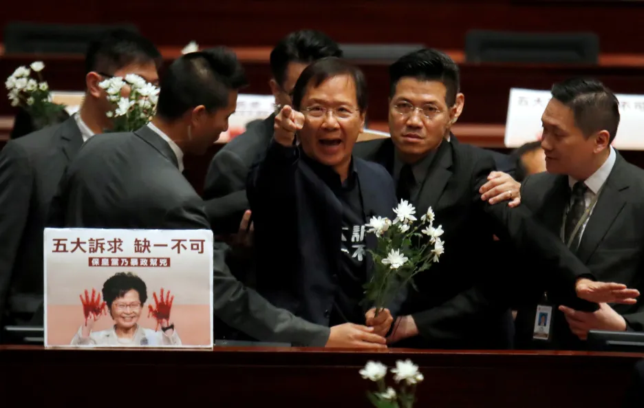 Prodemokratický poslanec je vyváděn z jednací síně hongkongského parlamentu