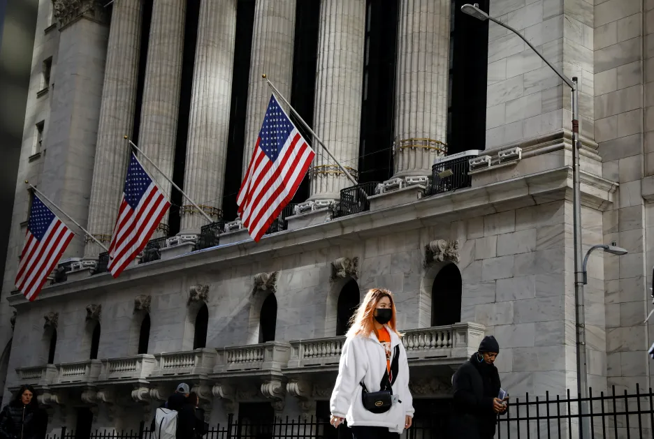 Žena s rouškou před newyorskou akciovou burzou NYSE