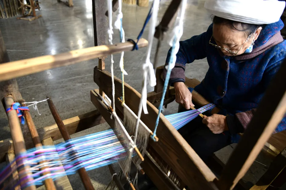 Prastarý národ Puejů se živí tkalcovstvím a šitím oděvů