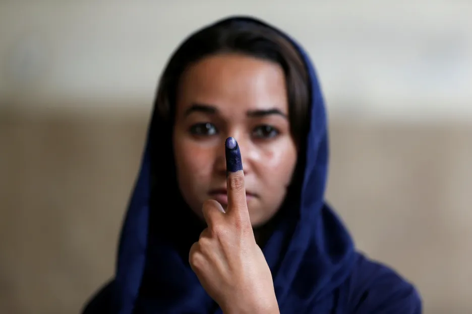 Afghánská žena s prstem od inkoustu po hlasování v prezidentských volbách v Kábulu v roce 2014