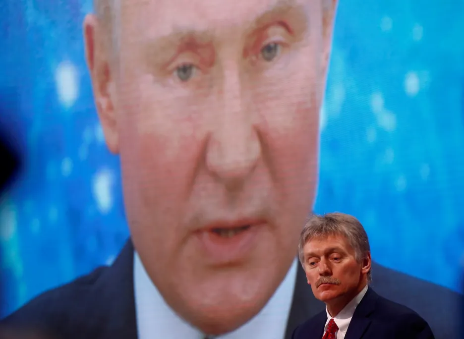 Mluvčí Kremlu Dmitrij Peskov před elektronickou obrazovkou s Vladimirem Putinem
