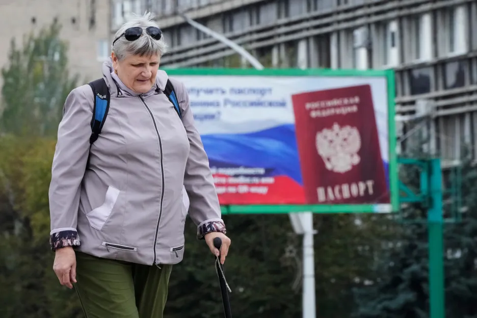 Žena prochází kolem billboardu s ruským pasem