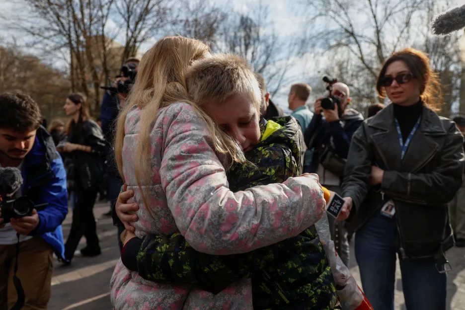 Matka objímá svého syna, který se vrátil potom, co ho unesli Rusové