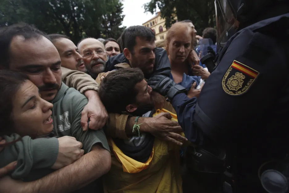 Španělská policie brání lidem v přístupu do hlasovací místnosti v Barceloně