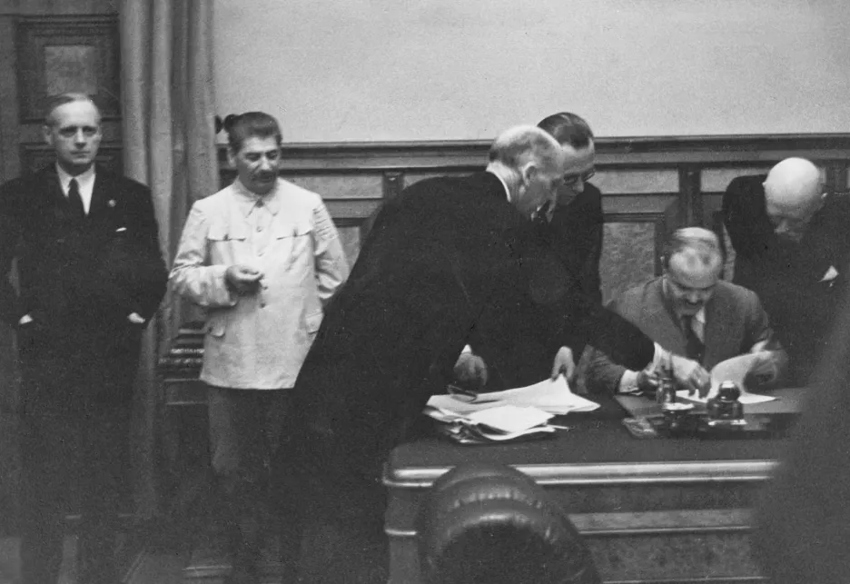 Vjačeslav Molotov podepisuje v Kremlu smlouvu s Německem. Vlevo na snímku německý ministr zahraničí Joachim von Ribbentrop a Josif Stalin