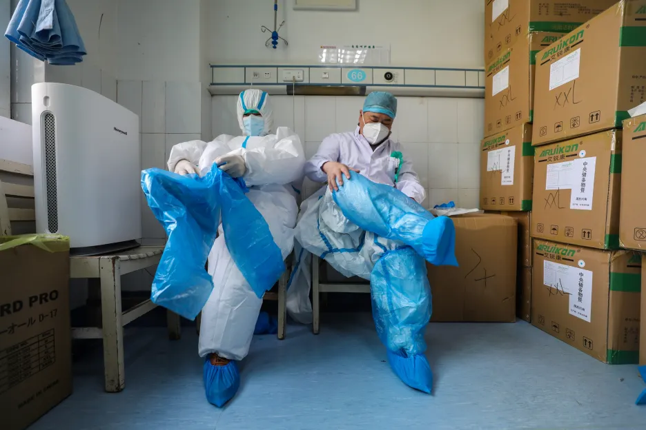 Zdravotníci v nemocnici v čínském Wu-chanu si oblékají ochranné obleky