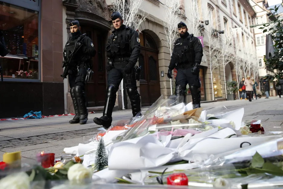 Policejní hlídka prochází kolem květin položených na místě úterního útoku