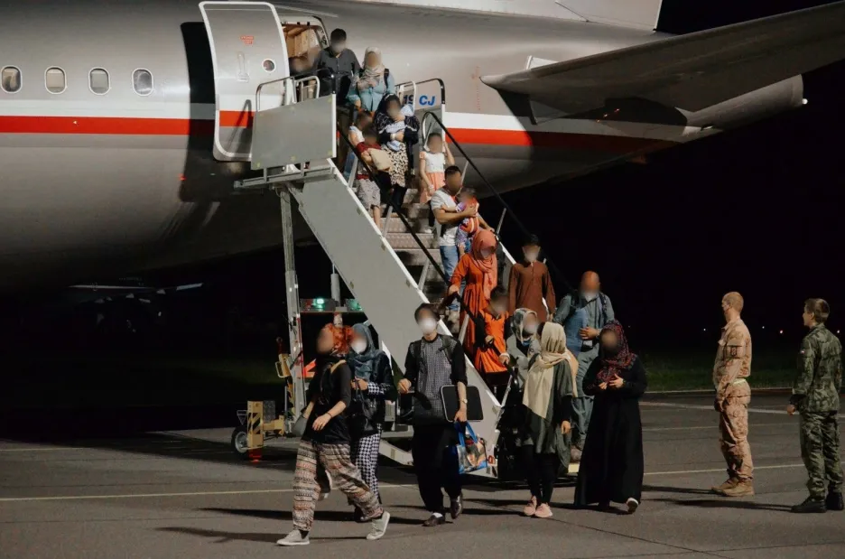 Pasažeři vystupuji na pražském letišti ve Kbelích z českého evakuačního letounu z Kábulu