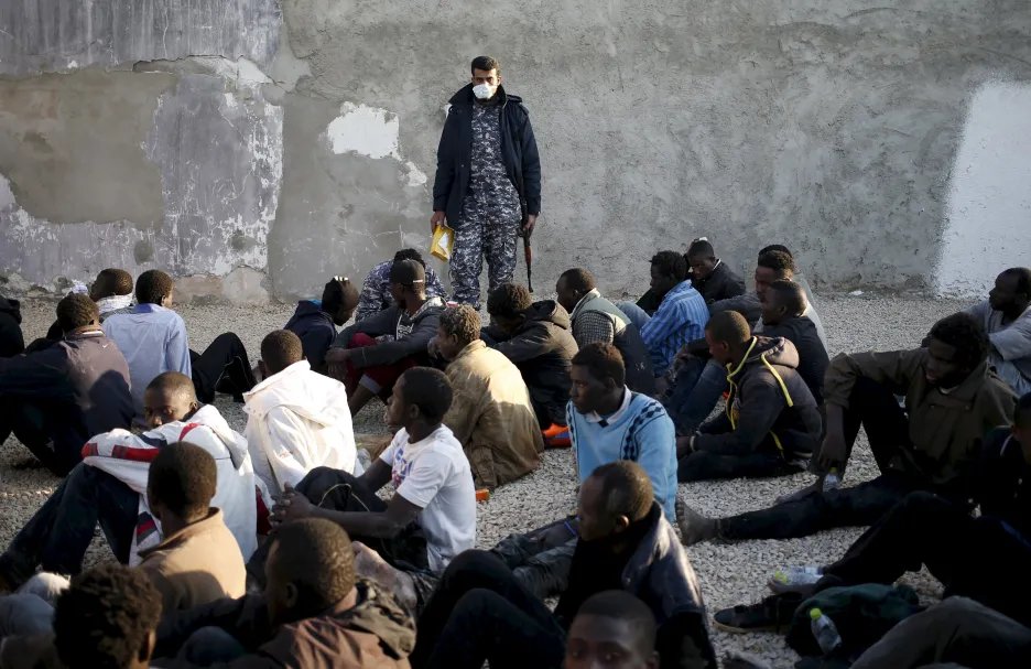 Policista v Tripolisu dohlíží na nelegální migranty