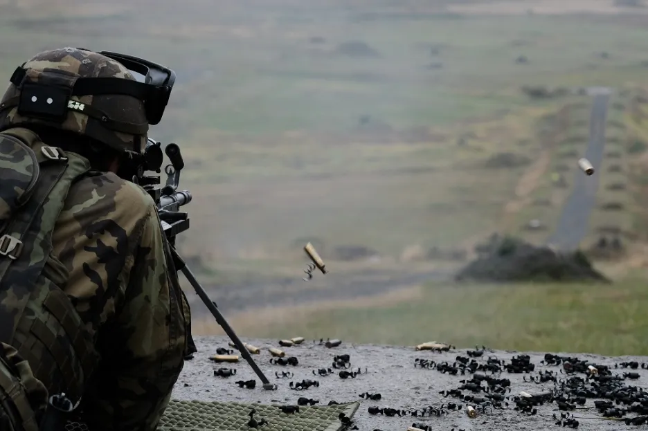 Střelba z lehkého kulometu FN Minimi. Na pravé straně fotky jsou vidět odlétávající nábojnice a článek pásu 