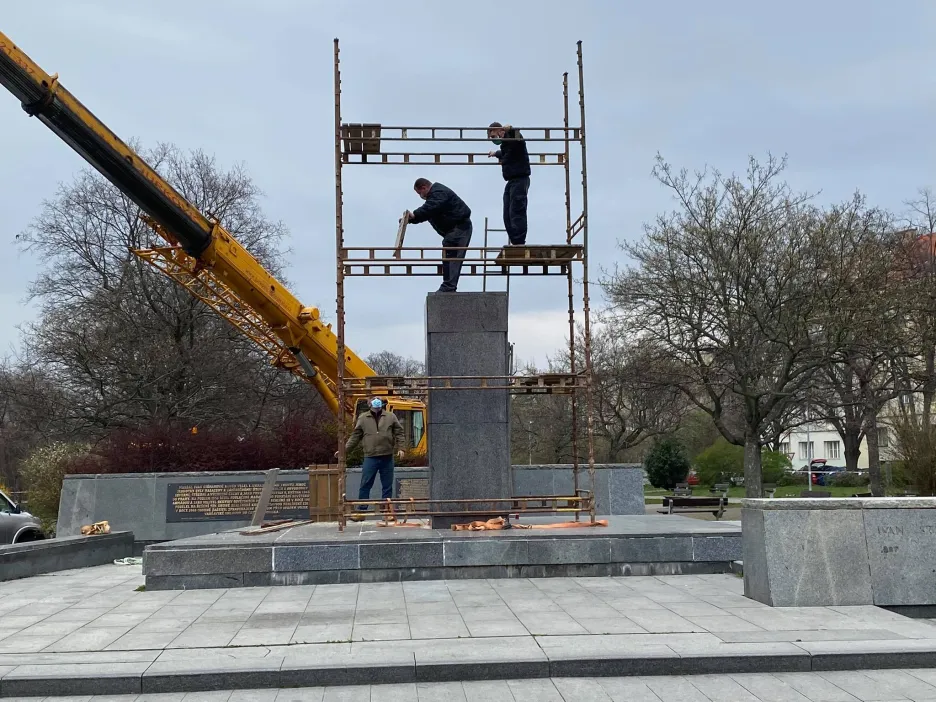 Dělníci na lešení kolem prázdného podstavce Koněvovy sochy