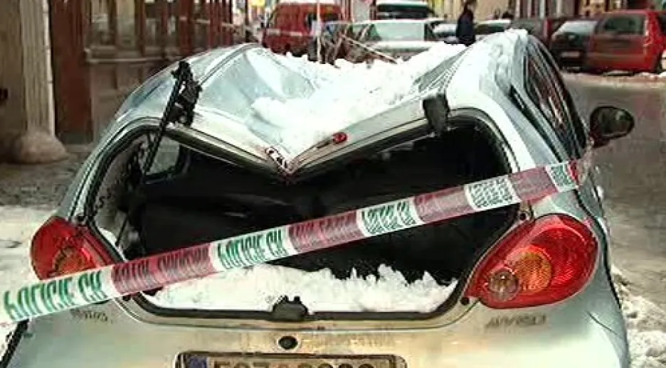 Sníh poškodil střechu zaparkovaného auta