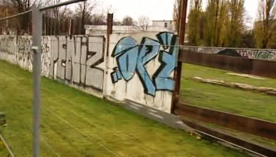 Část Berlínské zdi za ochranným plotem