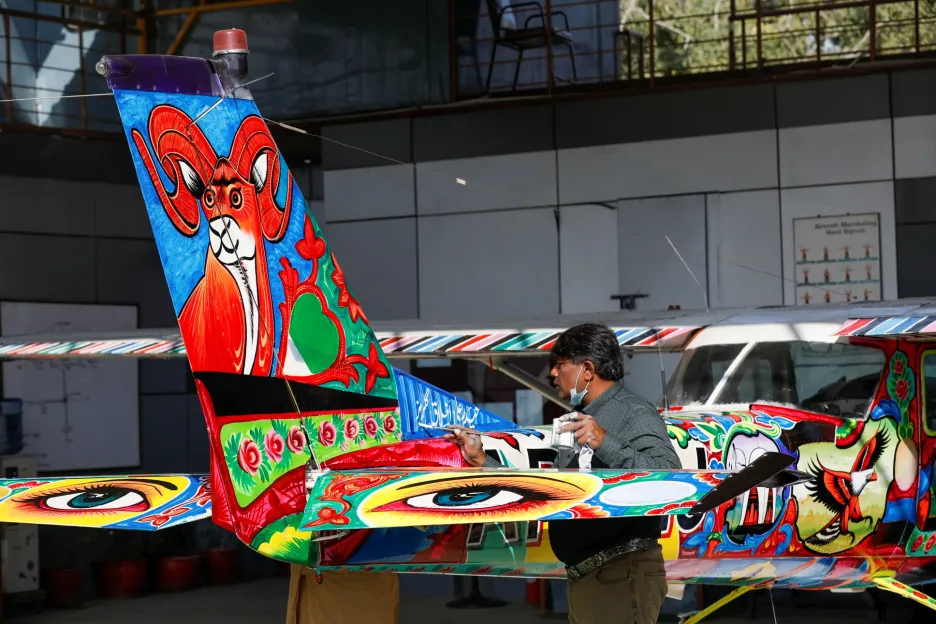 Umělečtí malíři zdobí letadlo Cesnna v jednom z hangáru na mezinárodním letišti v pakistánském Karáčí 