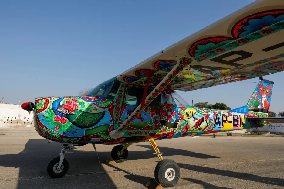 Umělečtí malíři zdobí letadlo Cesnna v jednom z hangáru na mezinárodním letišti v pakistánském Karáčí 